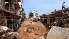 Zerstörte Fahrzeuge und beschädigte Gebäude in der libyschen Stadt Darna, etwa 290 Kilometer östlich von Bengasi (Bild: AFP)