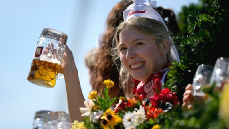 Diese Wiesn-„Prinzessin“ strahlt mit ihrem Bier und dem Wetter um die Wette. (Bild: AP)