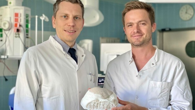Professor Christoph Griessenauer (l.) und Oberarzt Johannes Pöppe von der Uniklinik für Neurochirurgie mit dem Modell des Implantats. (Bild: SALK)