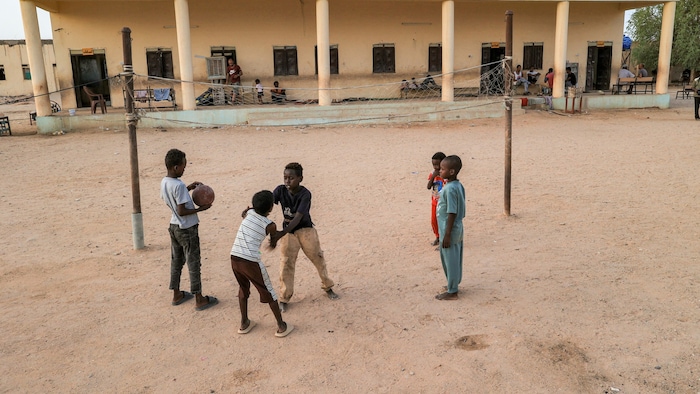 Kinder spielen auf dem Spielplatz einer Schule, die in eine Unterkunft für Vertriebene umgewandelt wurde.