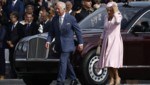 König Charles und Königin Camilla, deren Hut wegzufliegen droht, in Paris. (Bild: APA/AFP/POOL/Yoan VALAT)