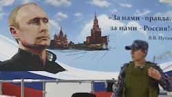 Auf dem für den russischen Präsidenten Wladimir Putin werbenden Plakat steht: „Wir stehen für die Wahrheit, wir stehen für Russland!“ (Bild: AFP/Michel RUBINEL)