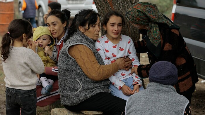 Ethnische Armenier trösten eine junge Frau bei ihrer Ankunft in Armenien.
