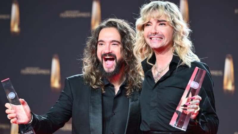 Die Musiker Tom Kaulitz (l) und Bill Kaulitz feiern mit ihrem Deutschen Fernsehpreis 2023 nach der Verleihung im Coloneum. (Bild: APA/dpa/Henning Kaiser)