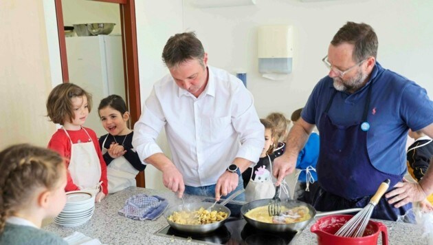 von links: Andreas Babler (SPÖ) und Sepp Schellhorn (früher NEOS) mit Kindern beim Kochen (Bild: Privat)