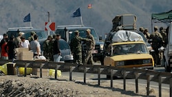 Flüchtlinge und EU-Beobachter bei einem militärischen Checkpoint in Bergkarabach (Bild: AP)