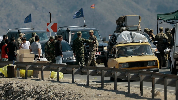 Flüchtlinge und EU-Beobachter bei einem militärischen Checkpoint in Bergkarabach