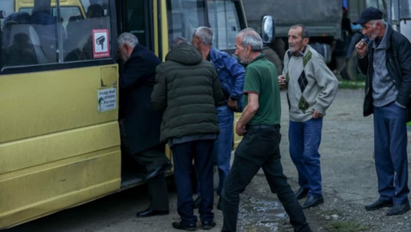 Armenier besteigen einen Bus, der sie aus der Region Bergkarabach - der völkerrechtlich nicht anerkannten Republik Arzach - bringt. (Bild: ASSOCIATED PRESS)