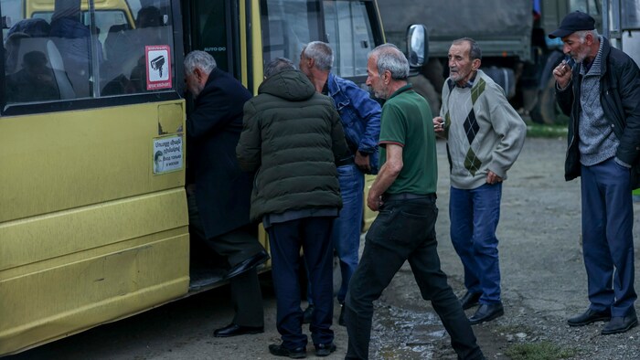 Armenier besteigen einen Bus, der sie aus der Region Bergkarabach - der völkerrechtlich nicht ...