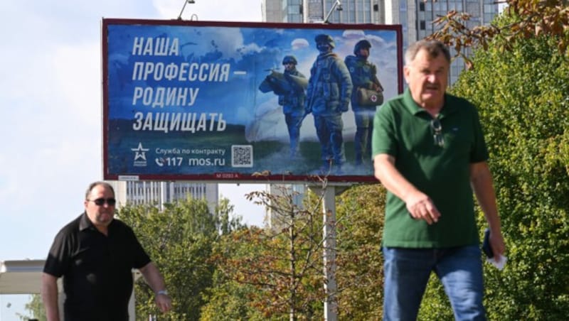 An jeder Ecke wirbt Russland für einen Einsatz im Krieg. Auf dem Bild ist eine Reklametafel in Moskau zu sehen. Auf ihr steht: „Unser Beruf ist es, die Heimat zu verteidigen“. (Bild: APA/AFP/NATALIA KOLESNIKOVA)