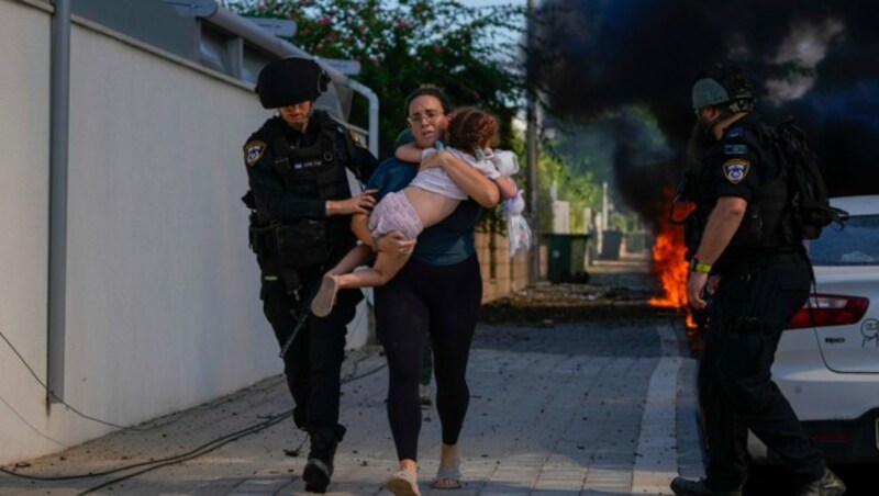 Die israelische Polizei evakuiert eine Frau und ein Kind, nachdem die Stadt Aschkelon im Süden Israels von Raketen getroffen worden war. (Bild: ASSOCIATED PRESS)