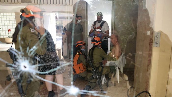 Israelische Rettungsteams kümmern sich um einen älteren Mann. Das Gebäude, in dem er sich ...