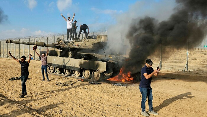 Palästinenser bejubeln die Zerstörung eines israelischen Panzers an der Grenze.