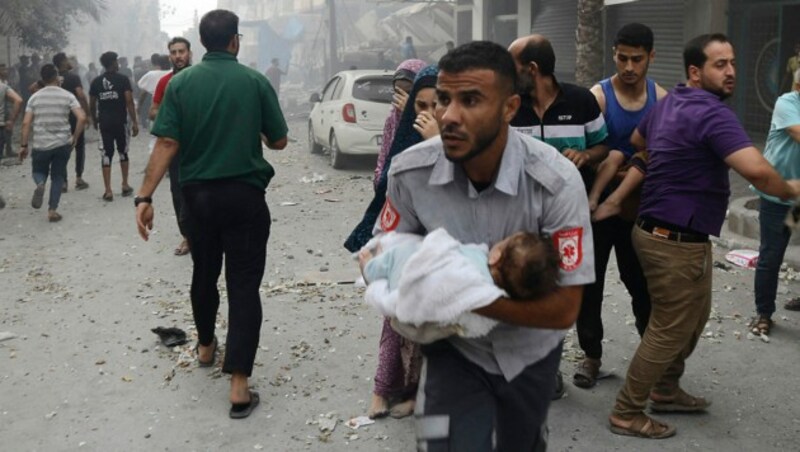 Dieses palästinensisches Kind wurde nach einem Luftschlag der Israelis unter den Trümmern eines Gebäudes begraben, konnte aber gerettet werden. (Bild: APA/AFP/Eyad AL-BABA)