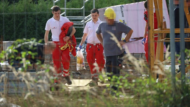 Rot-Kreuz-Mitarbeiter und Handwerker am Unfallort in Lambach (Bild: laumat.at)