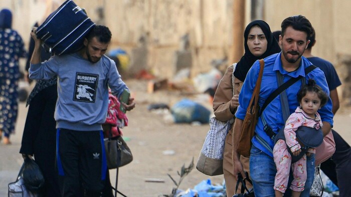 Flucht aus Gaza. Mit Beuteln und Koffern in der Hand und Kindern auf dem Arm verlassen Menschen ...