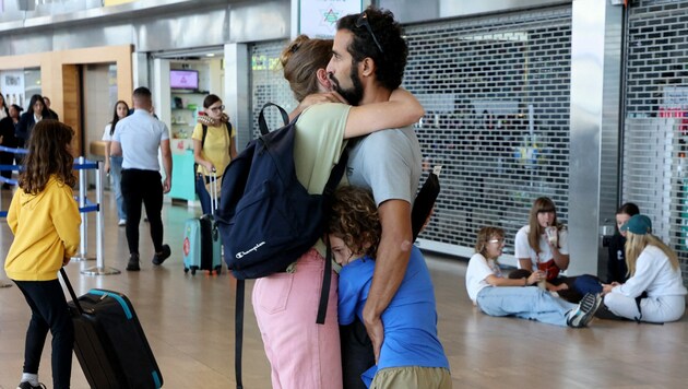 Eine Familie umarmt sich im Flughafen Tel Aviv. (Bild: AFP)