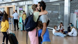 Eine Familie umarmt sich im Flughafen Tel Aviv. (Bild: AFP)