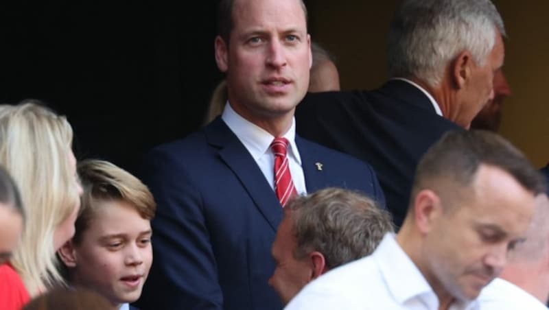 Während William gespannt das Rugby-Spiel beobachtete, plauderte George mit einem Sitznachbarn. (Bild: APA/AFP/Pascal GUYOT)