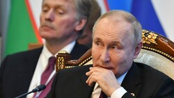 Wladimir Putin mit Kreml-Sprecher Dmitri Peskow (im Hintergrund) (Bild: AFP)