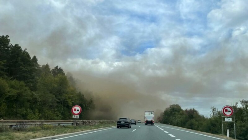 Man könnte meinen, dichte Rauchschwaden ziehen über die Inntalautobahn bei Vomp (Bezirk Schwaz). Doch bei dieser Wolke handelt es sich um Staub, den der Sturm von einer nahegelegenen Schottergrube aufwirbelt. (Bild: zoom.tirol)