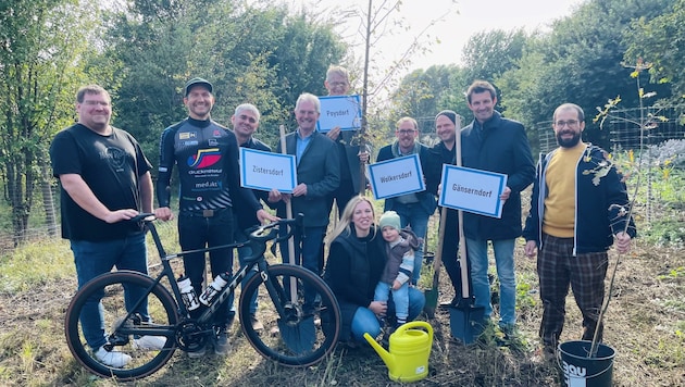 Top-Biker Kaider im Dress mit Sponsoren und Bürgermeistern: 67 Pflanzen gleichen CO2 der Begleitautos aus. (Bild: LT-Direktion/Schultes)