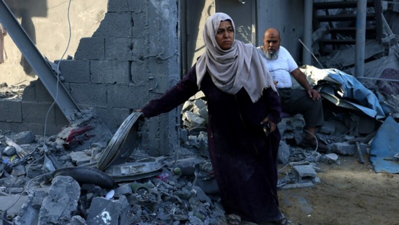 Zivilpersonen vor einem zerstörten Haus (Bild: APA/AFP/SAID KHATIB)