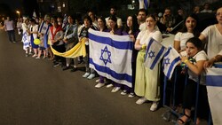 Demonstranten, die die israelische Flagge und ein gelbes Band halten, fordern die Freilassung der israelischen Geiseln. (Bild: AFP )