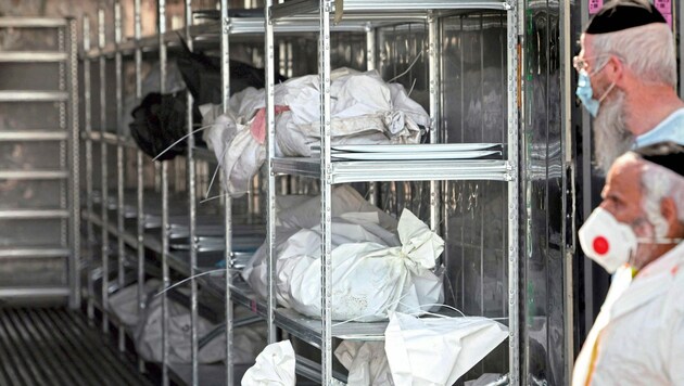 Im Sammelzentrum werden die Leichen in Plastiksäcken gestapelt. (Bild: AFP)