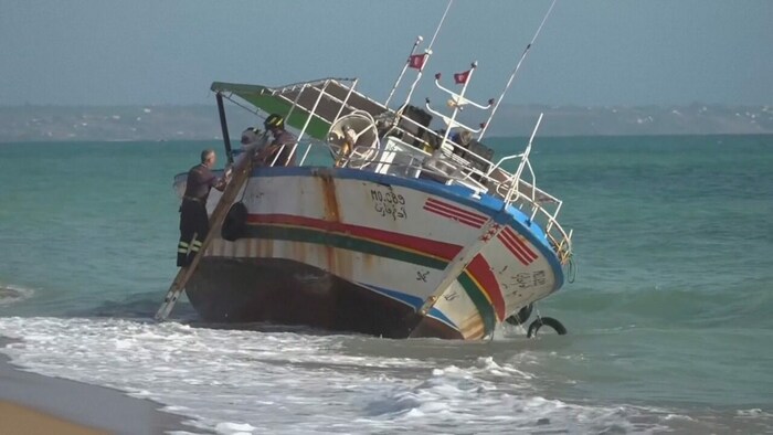 Feuerwehrleute untersuchten das Schiffswrack nach Hinweisen.