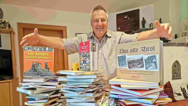 Martin Reiter mit den 125 Büchern, die er im Wohnzimmer gestapelt hat.
