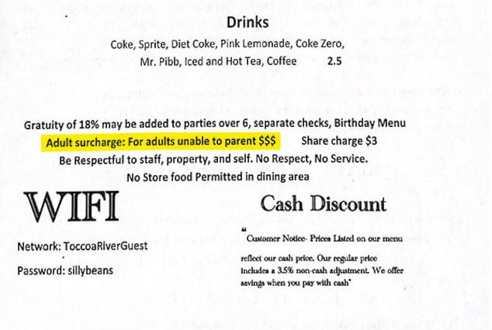 Auf der Karte des Toccoa Riverside Restaurants steht der „Erwachsenzuschlag für Erwachsene, die nicht in der Lage sind, Eltern zu sein $$$“.