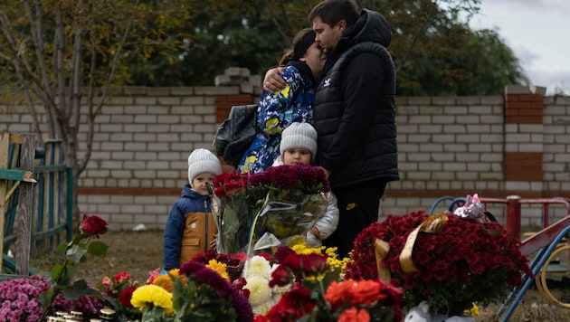 Eine Familie trauert bei einem Begräbnis in der Nähe von Charkiw. (Bild: AP)