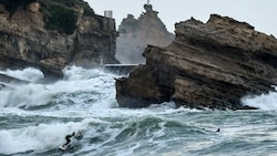 Die hohen Wellen hielten manche Menschen in Frankreich nicht ab, surfen zu gehen. (Bild: AFP)