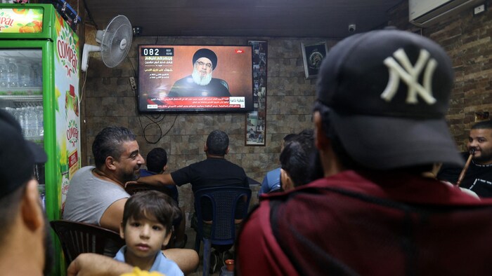 Menschen verfolgen die Rede in einem Café in Beirut.