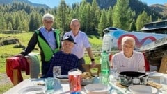 Bei strahlendem Sonnenschein genoss Leonhard (2. v. li.) ein Essen vor „seiner“ Almhütte. (Bild: Rotes Kreuz Salzburg)