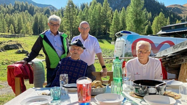 Bei strahlendem Sonnenschein genoss Leonhard (2. v. li.) ein Essen vor „seiner“ Almhütte. (Bild: Rotes Kreuz Salzburg)