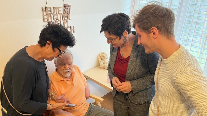 Pflegerin Monika Herrnegger (l) zeigt ihrem Patienten und Landesrätin Beate Prettner (2vr) und Gründer Marcel Schmidberger (r) die App. (Bild: Felix Justich)