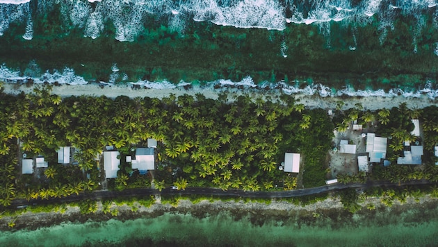 In dieser Luftaufnahme von Tuvalu ist einer der schmalsten Teile der Insel zu sehen, wo das Land das Meer von der Lagune trennt. (Bild: Tala - stock.adobe.com)