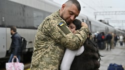 Ein Paar verabschiedet sich auf einem Bahnsteig in der Region Donezk.  (Bild: AFP)