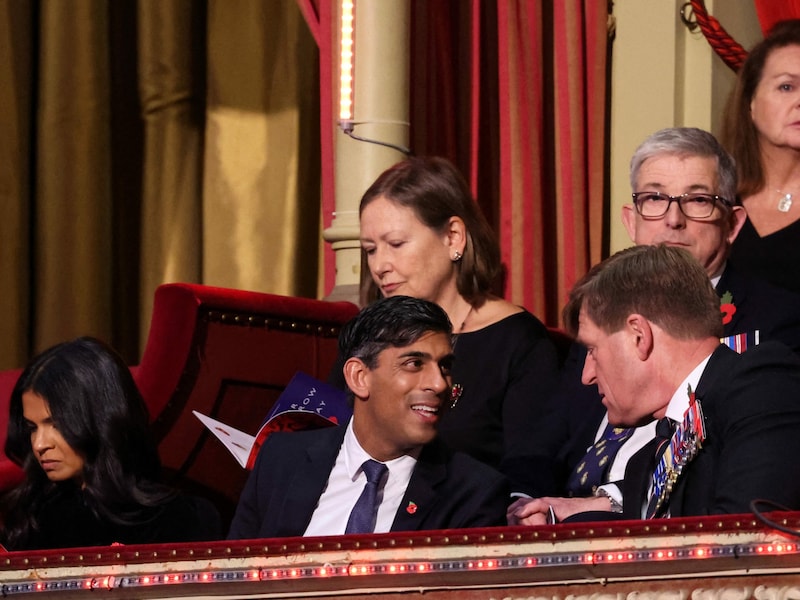 Der britische Premierminister Rishi Sunak (Mitte) und seine Frau Akshata Murthy (links) beim Konzert (Bild: APA/AFP/POOL/Chris Jackson)