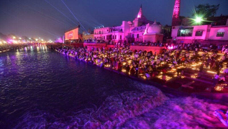 Hindus zünden am Vorabend von Diwali, dem hinduistischen Lichterfest, in Ayodhya am 11. November 2023 irdene Lampen am Ufer des Sarayu-Flusses an. (Bild: APA/AFP/SANJAY KANOJIA)