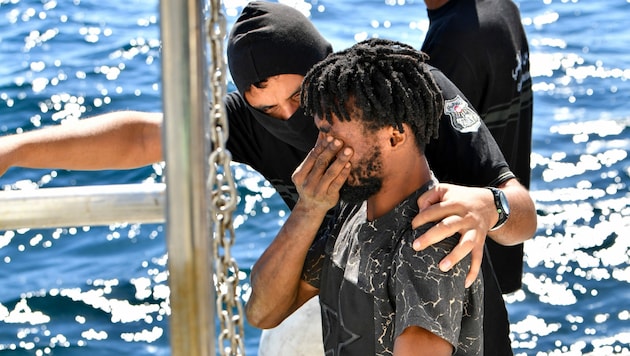 Ein Mittelmeer-Flüchtling in Begleitung der tunesischen Küstenwache (Bild: AFP)