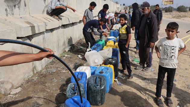 Civilek vizet hoznak a Gázai övezetben. (Bild: AFP)
