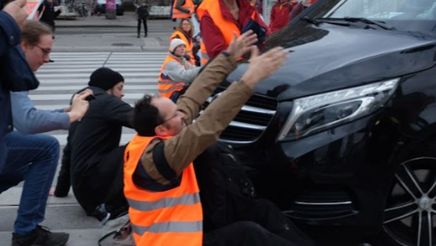 Ein Aktivist versucht einen Autolenker am Wegfahren zu hindern. (Bild: Letzte Generation AT)