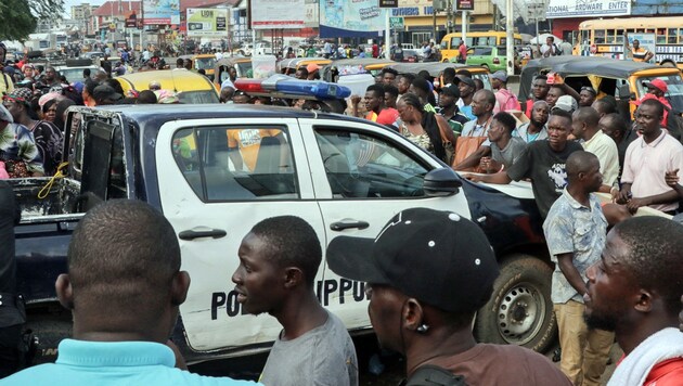 Ein liberianischer Polizeiwagen inmitten einer Menschenmenge (Archivbild) (Bild: APA/AFP/EMMANUEL TOBEY)