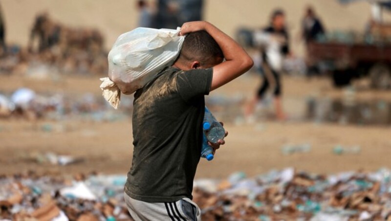 Ein palästinensischer Jugendlicher trägt gelieferte Wasserflaschen nach Hause. (Bild: APA/AFP/MOHAMMED ABED)