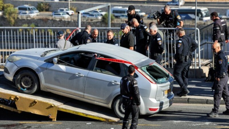 Unter massivem Polizeiaufgebot wird das Auto der Attentäter vom Tatort gebracht. (Bild: APA/AFP/AHMAD GHARABLI)