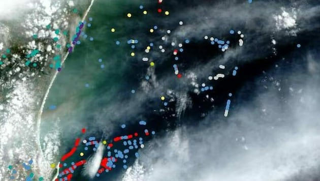 Auch bei schwierigen atmosphärischen Bedingungen kann die neue KI den Plastikmüll identifizieren. Die roten Punkte zeigen bei einem Testlauf korrekt erkanntes Plastik. (Bild: ESA/„Cell iScience“)