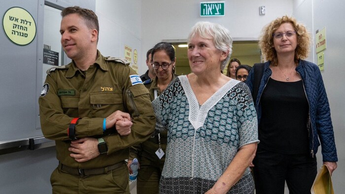 Ein israelischer Soldat geleitet eine freigelassene Geisel durch ein Krankenhaus.